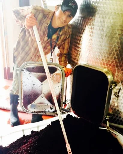 Man working with a stainless steel wine tank in Liquid Art Winery in Kansas, USA.