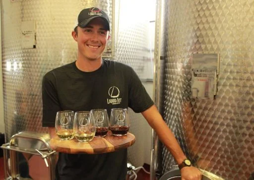 Man holding wine in Liquid Art Winery in Kansas, USA.