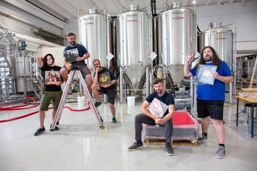 Brewers taking a picture in front of their conical beer fermenters in the Varionica brewery in Croatia.