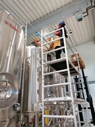 Men cleaning conical fermenters in the Varionica brewery in Croatia.